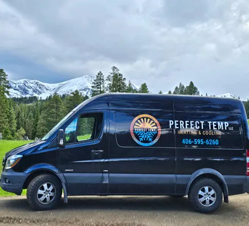 The black Perfect Temp van parked below snow-capped peaks
